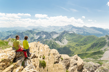 Pareja joven en la cima de una montaña mirando el impresionante paisaje. Concepto de vacaciones de...