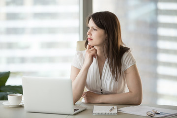 Thoughtful doubtful businesswoman looking away contemplating thinking of problem solution, serious uncertain employee unsure about difficult question deciding planning searching new ideas at work