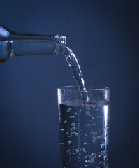 Pouring water from bottle into glass