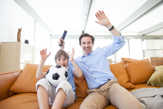 Boy Watching Soccer Match With Father