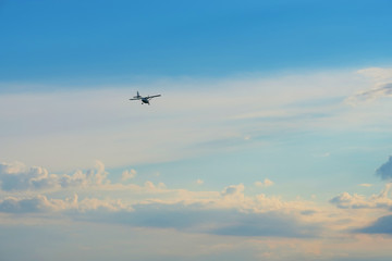 Fototapeta na wymiar A small plane in the cloudy sky