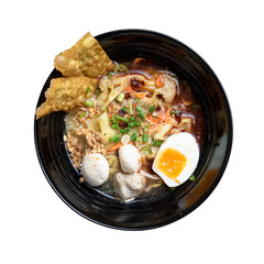 Thai spicy noodle,Thai yellow noodle tom yum with pork,egg and meat ball isolated on white