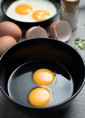 Cracked eggs in bowl and egg shells for cooking