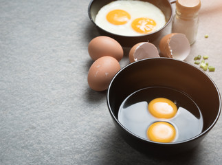 Cracked eggs in bowl and egg shells for cooking