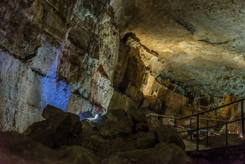 Under the ground. Beautiful view of stalactites and stalagmites in an underground cavern - New Athos Cave. Sacred ancient underworld formations.
