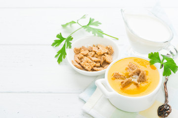 Healthy vegetarian pumpkin soup with parsley on wooden table