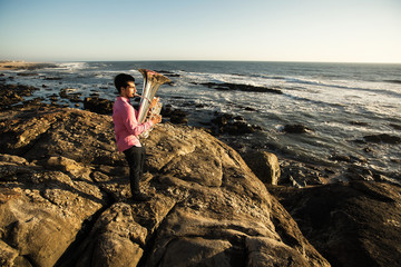 Musician play to Tuba on romantic sea shore.