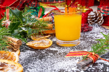Fototapeta na wymiar Christmas Slate Platter. Decorated Slate Platter, with a glass of chilled fresh Orange Juice, ready for Festive food to be served.