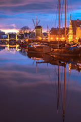 View of the canals of the city of Leiden with hoses, ships and boats at sunset. View of city channel with ships, the city of Leiden, Netherlands.