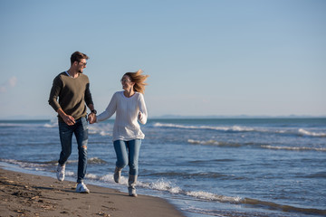 Loving young couple on a beach at autumn sunny day