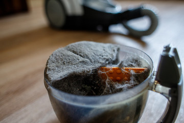 Trash and dust into the plastic cleaner container. Close up