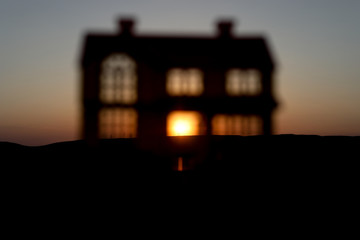 decorative small metallic house on the sunset background. Selective focus