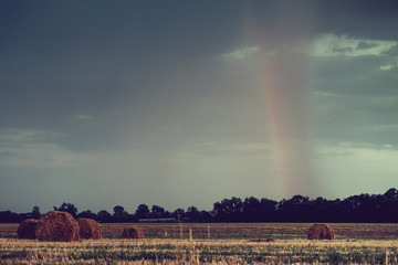 A rainbow against an early morning landscape in rural.