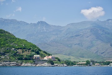 Fototapeta premium Background of greened rocks and houses at the seaside