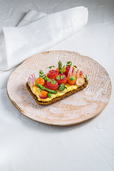 Smorrebrod, traditional Danish open sanwiches, dark rye bread with salmon, cream cheese and capers. Top view