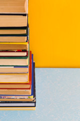 Stack of old books isolated on yellow background