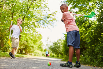 Two kids play street hockey