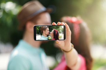 Happy couple taking self portrait photos with smart phone. Love, relationship, romance concept.