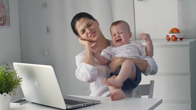 Crying baby with tired mother
