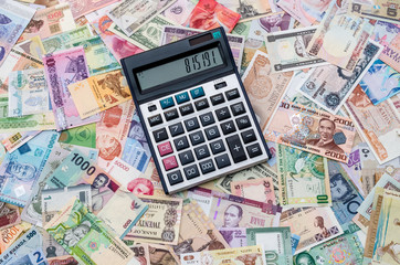 Calculator on collection of different countries banknotes