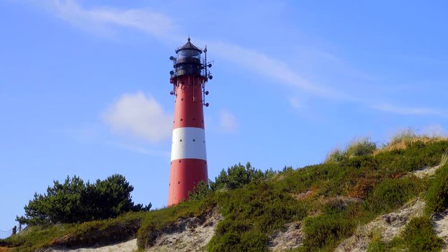 Wundersch&ouml;ner Leuchtturm H&ouml;rnum Sylt mit D&uuml;nen Landschaft  und blauen Himmel

