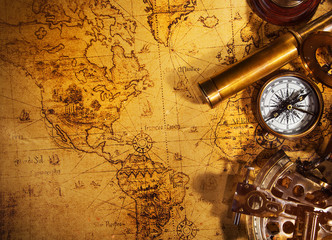 Old vintage navigation equipment on old world map.