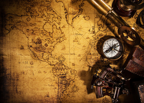 Old vintage navigation equipment on old world map.