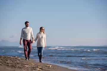 Loving young couple on a beach at autumn sunny day