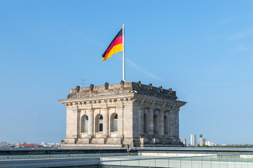 Roof of Reichstag (Bundestag) building with german flag on the tower.