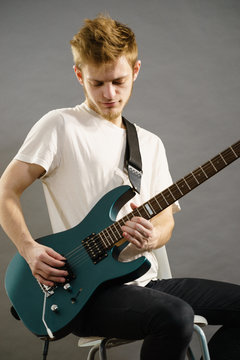 Young man playing electric guitar