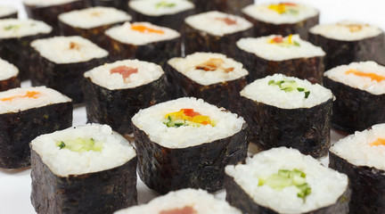 Traditional japanese sushi with salmon, tuna, eel and vegetables on a white background close up.