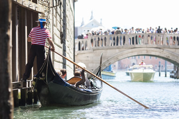 Fototapeta na wymiar Venice, Italy - May 21, 2017: The gondola floats along the old narrow street in Venice. Gondola is the most attractive tourist transport in Venice.