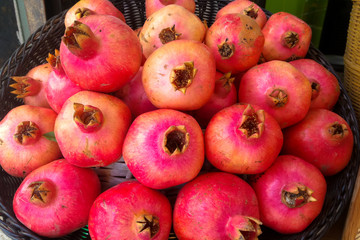 view from the top of a group of ripe pomegranates in a basket of straw for Rosh Hashana in Israel