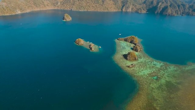 aerial footage small rocky islands in the lagoon with turquoise water. Busuanga, Palawan. coral reef and blue lagoon