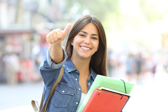 Happy student posing with thumbs up in the street