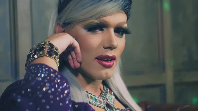 travesty-diva. The concept of the transvestite show. Man-actor turns into a woman. he dances, sings and poses on camera. 4k, slow motion, shooting steadicam