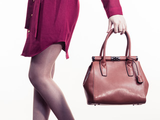 Female holding brown leather bag