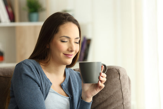 Relaxd woman enjoying a cup of coffee on a couch