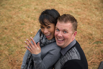 An engaged couple shows the engagement ring