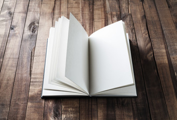Blank open book on wooden table background.