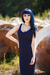 Portrait of beautiful young woman with blue hair, wearing a elegant blue dress