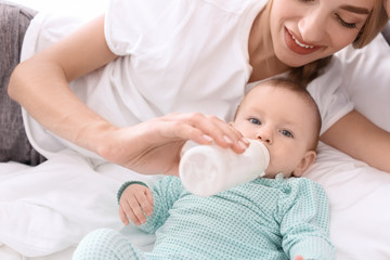 Woman feeding her child in bedroom. Healthy baby food