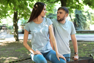 Young couple wearing gray t-shirts in park