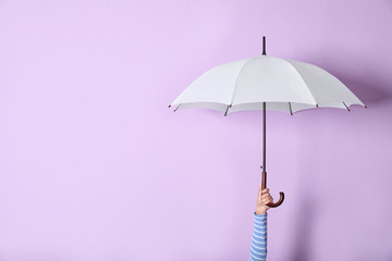 Person holding bright open umbrella on color background with space for design