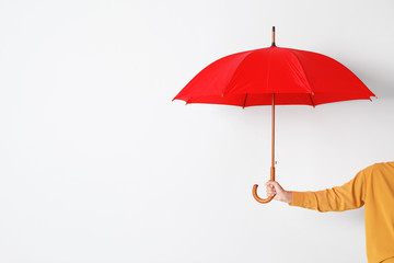 Person holding open umbrella on white background with space for design © New Africa