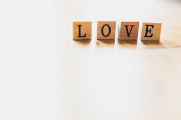 Obraz premium Word love on wooden dice and white background.