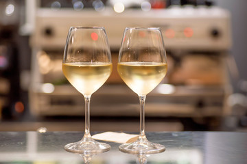White wine glasses in bar. Date time for two people inside restaurant or cafe