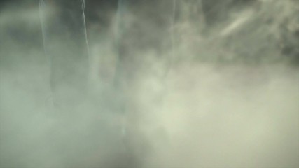 The legs of a man walking near a cloud of smoke. evening night time, slow motion