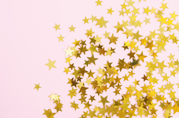 Yellow stars confetti on pink background.