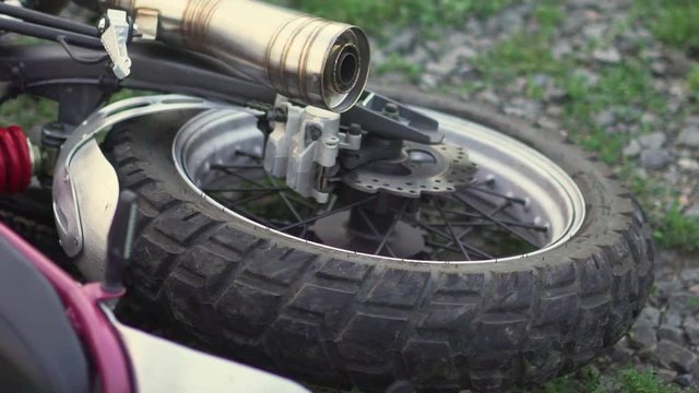 Close-up shot of motorcycle wheel on ground after an accident crash or fall . Slow motion 